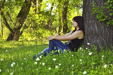 Girl sitting under a tree